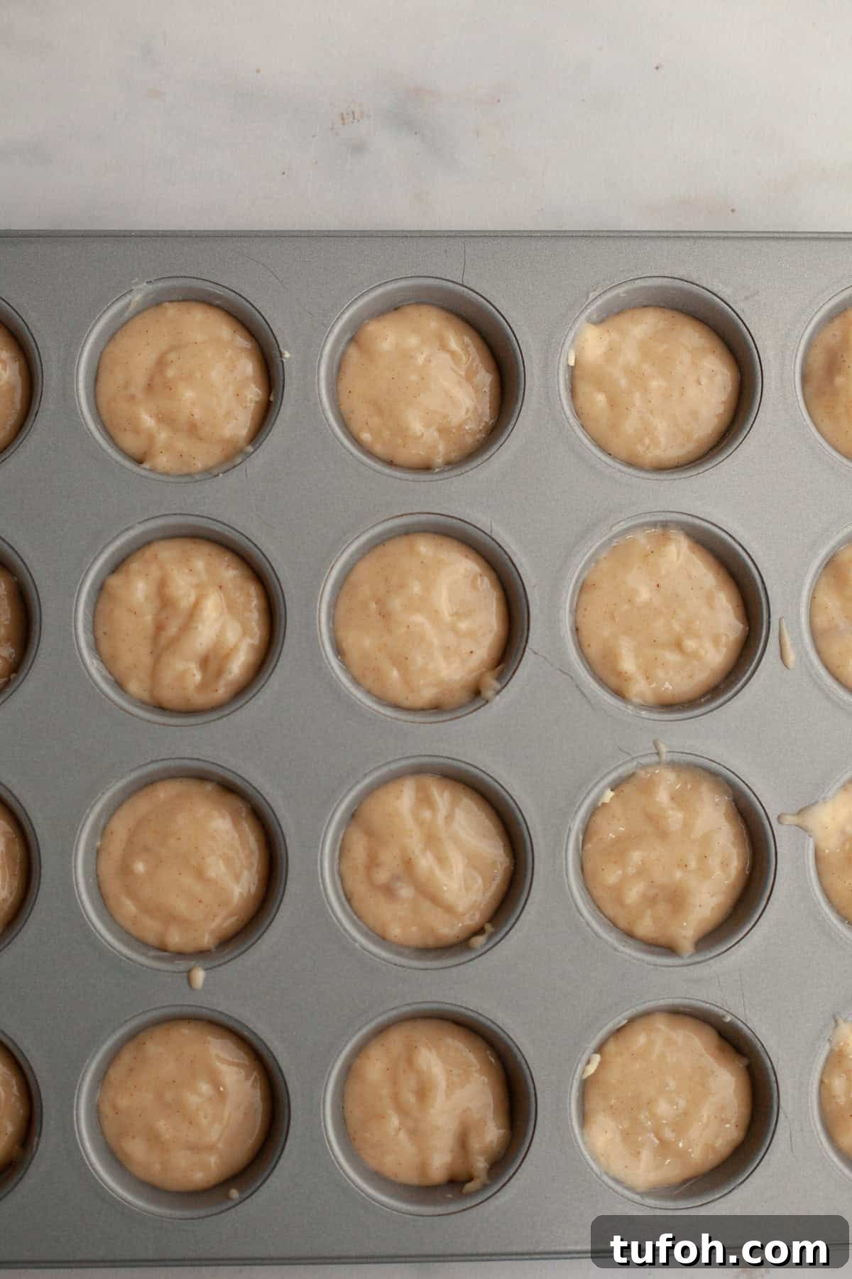 Cinnamon Mini Muffins Recipe: Quick, Soft & Flavorful 6 Mini muffin pan filled with unbaked muffin batter.