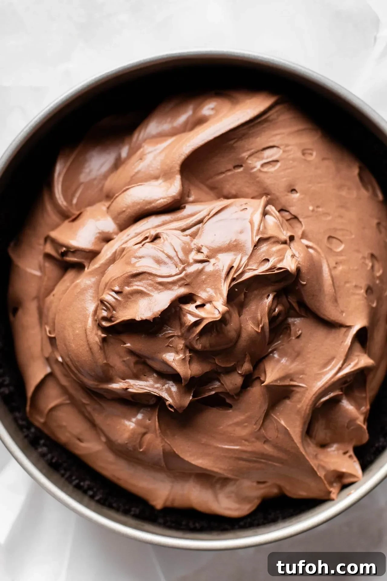 no bake chocolate cheesecake filling poured over crust in springform pan