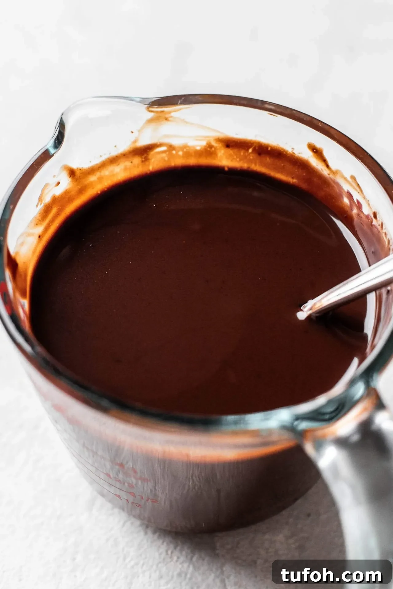 no bake chocolate cheesecake ganache in measuring cup
