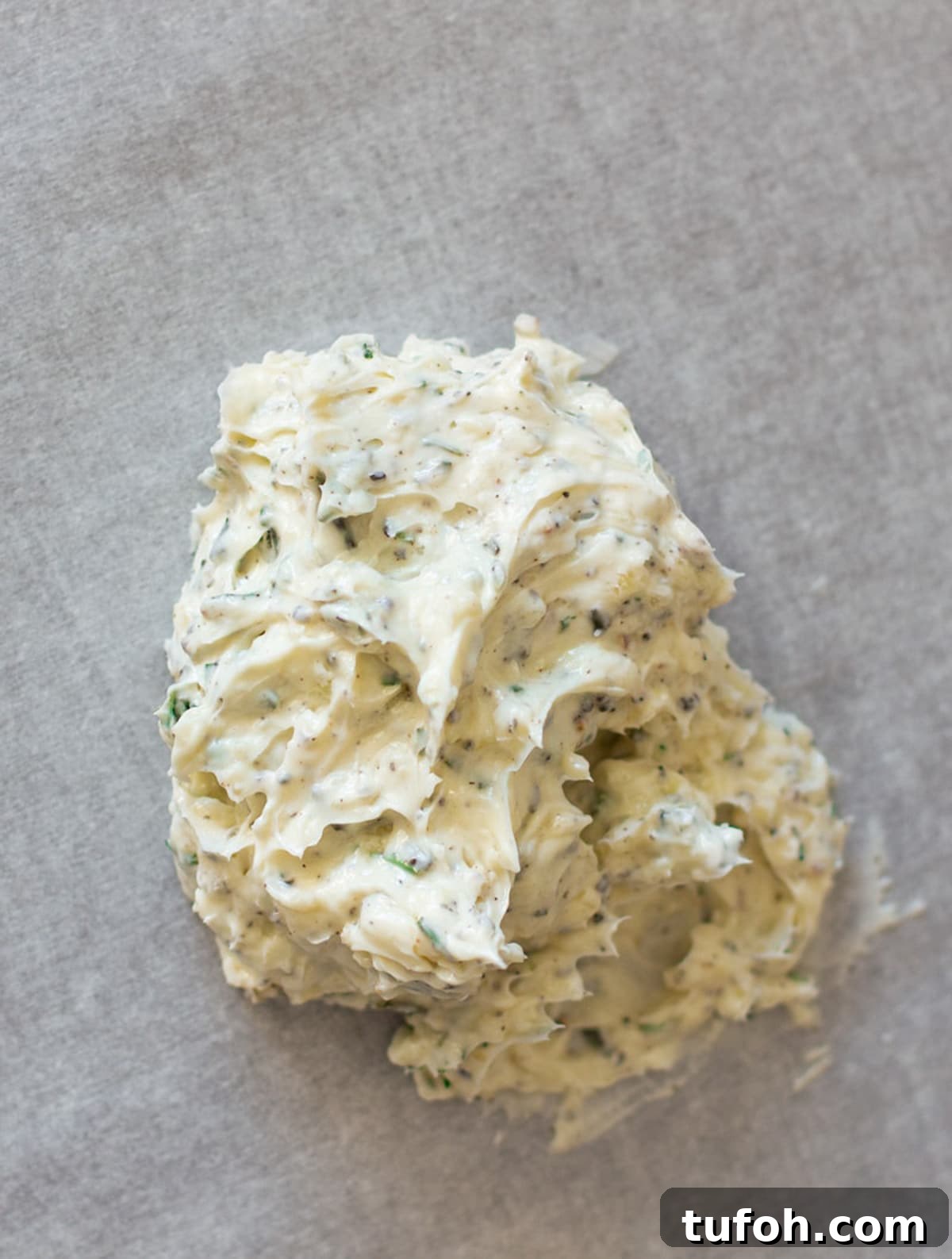 Rosemary Compound Butter for Steak, Chicken, Vegetables and More 6 Dollop of herb compound butter on parchment paper.