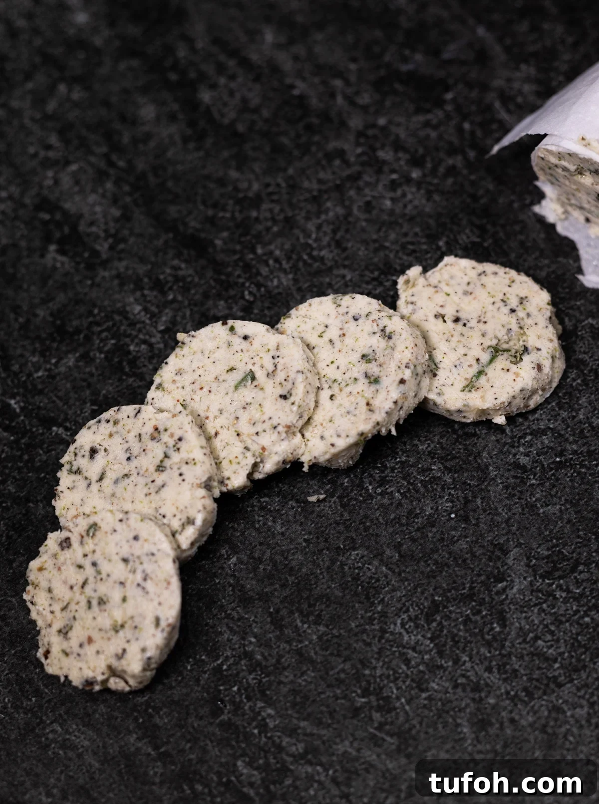 Rosemary Compound Butter for Steak, Chicken, Vegetables and More 9 pieces of flavored butter rounds on a table.