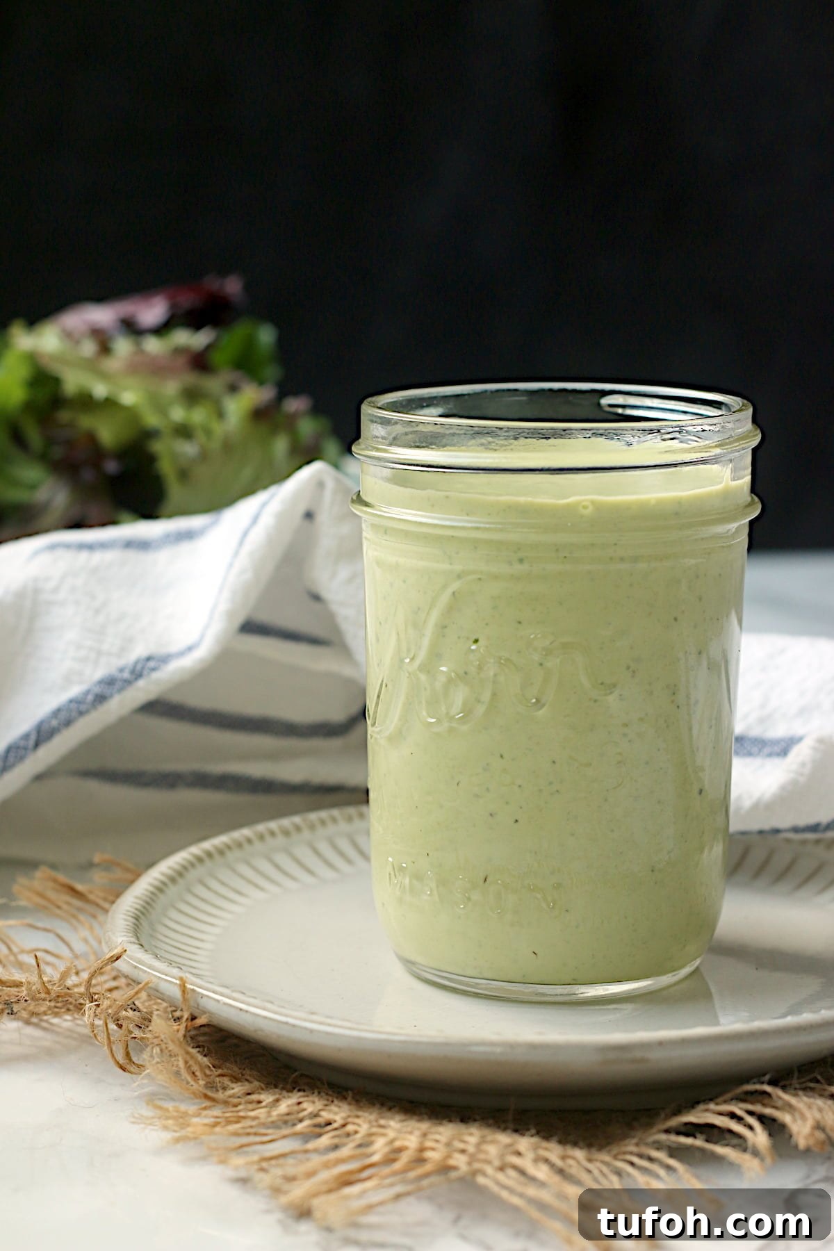 Homemade creamy pesto salad dressing in a jar.