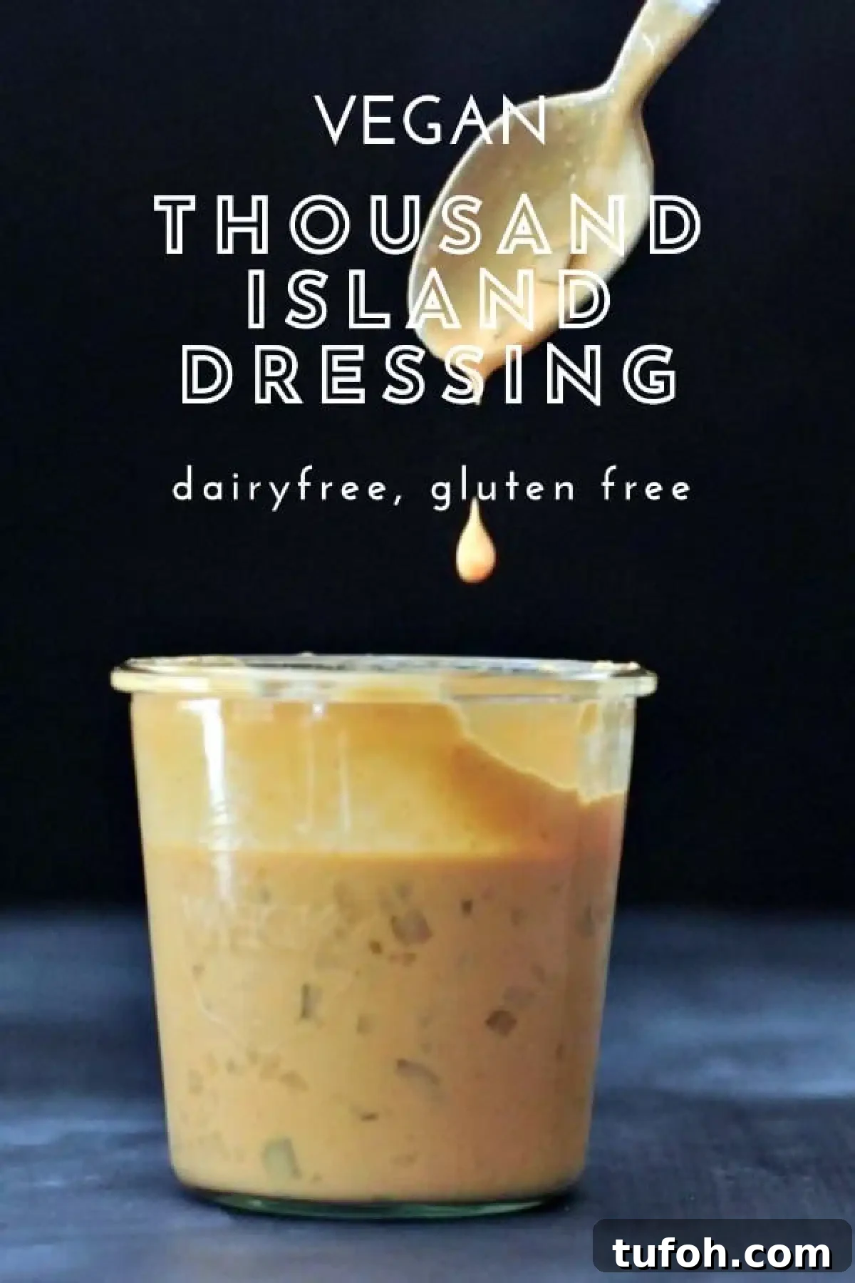 Vegan Thousand Island Dressing @spabettie #dairyfree #glutenfree #vegan #frysauce A large glass Weck jar of vegan thousand island dressing, with a spoon dripping sauce above the jar against a black background.