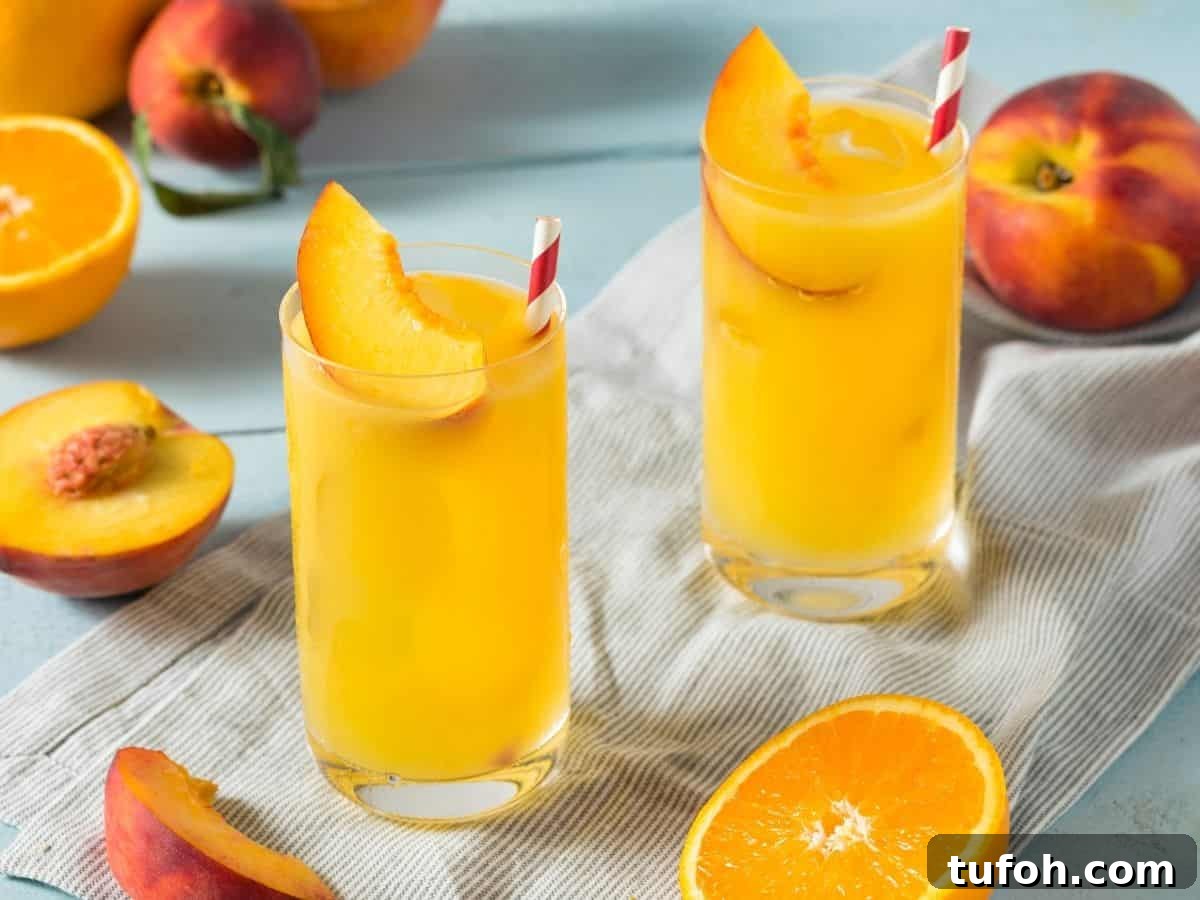 Orange peach fuzzy navel cocktail with a straw.