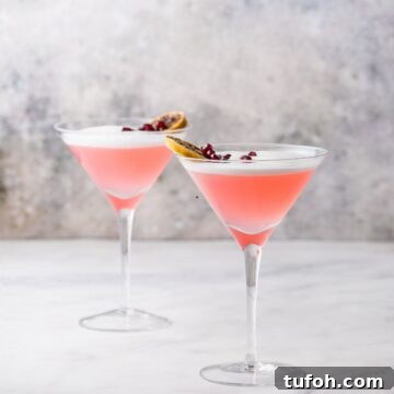 Two martini pink cocktail drinks on table.