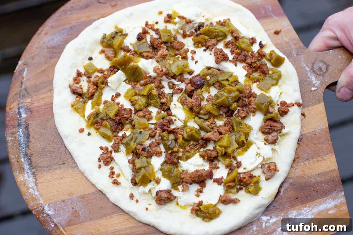 Green Chile and Chorizo Pizza Recipe with Melty Cheese 3 Green chile pizza toppings on dough before going in the oven.