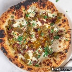 Green Chile and Chorizo Pizza Recipe with Melty Cheese 6 Grilled Green Chile Pizza on a wooden board.