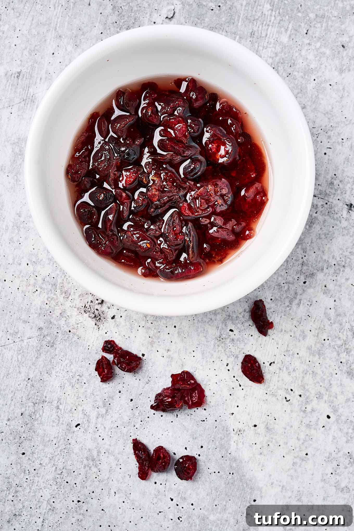 Cranberry Orange Bar Recipe — Tart, Chewy Holiday Dessert 5 Dried cranberries in a bowl, soaking in hot water to plump them up for baking into cranberry bars.