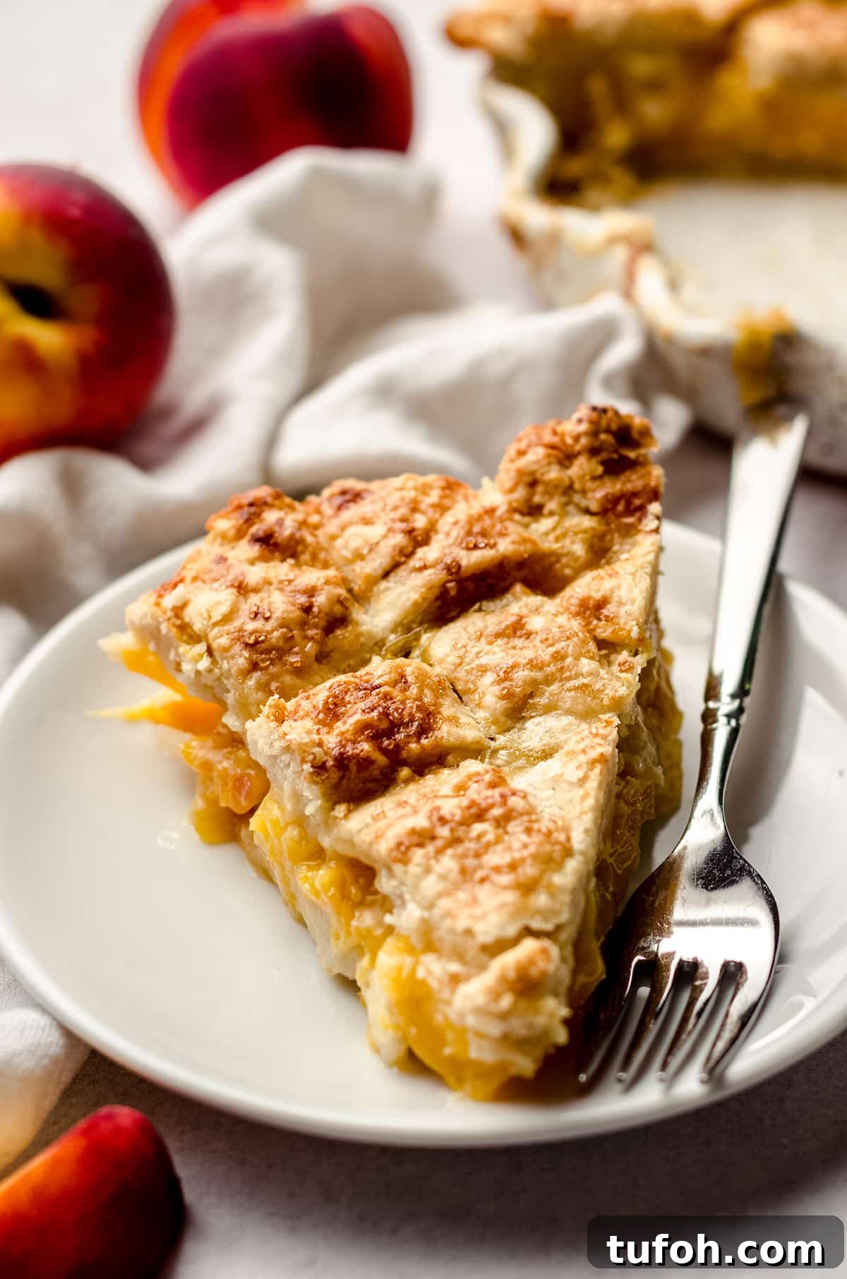A slice of peach pie on a white plate.
