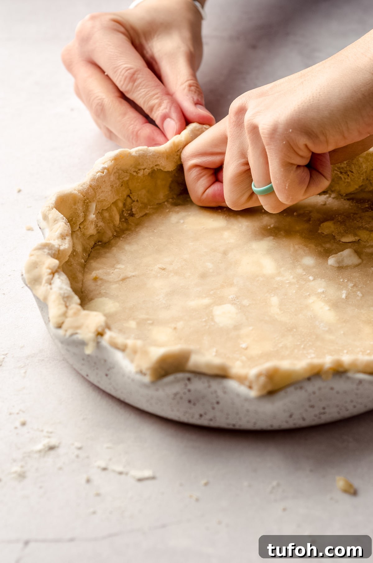 crimping a pie crust into a pie plate