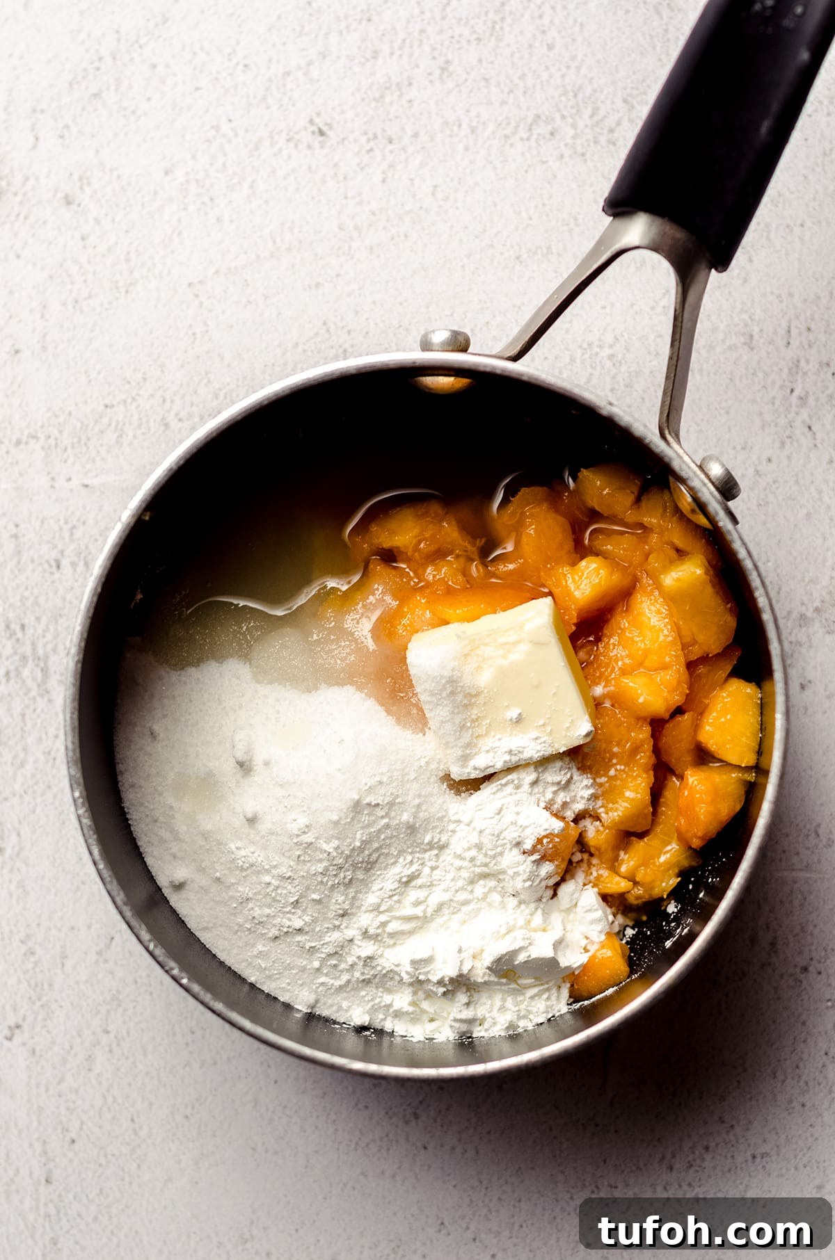 Preparing the peach filling for a pie.