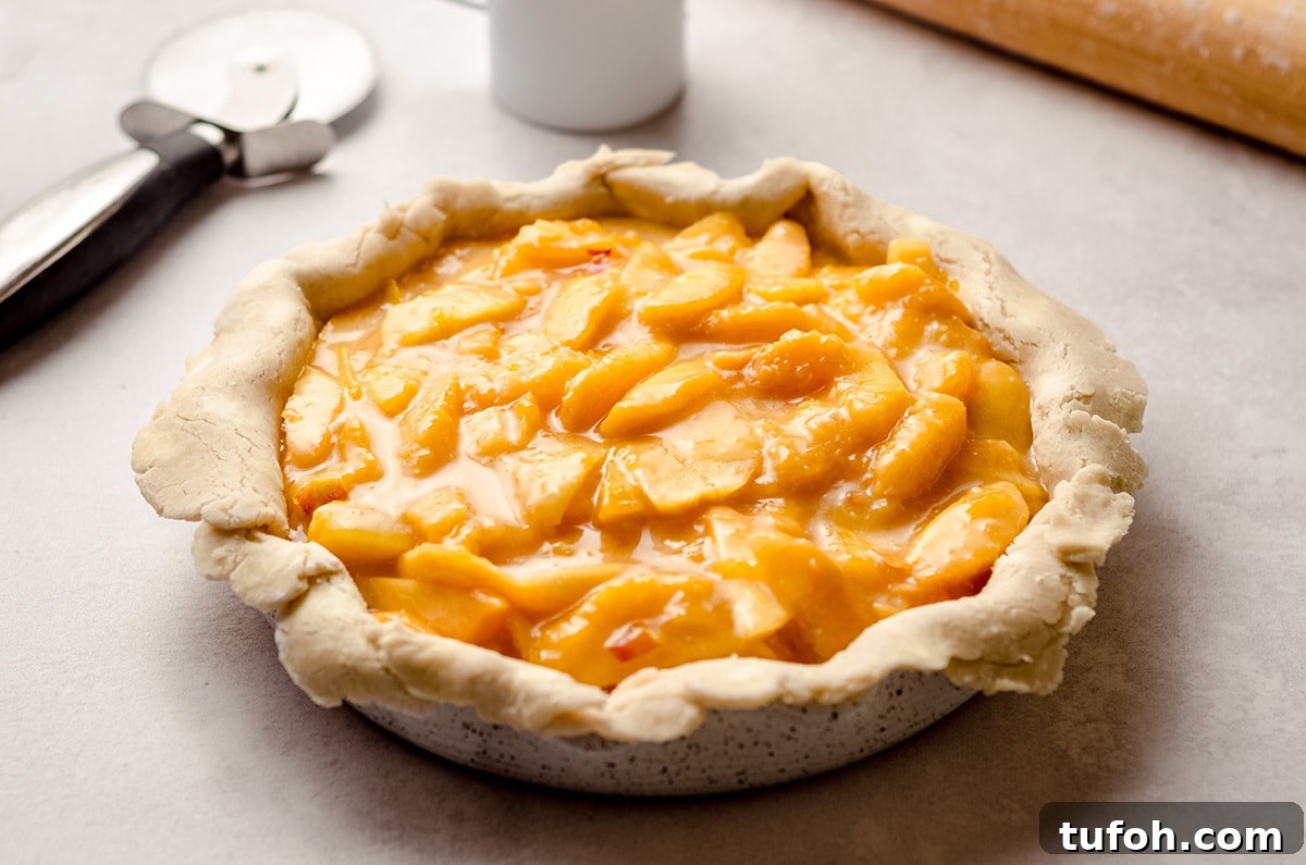 A pie crust filled with a fresh peach filling.