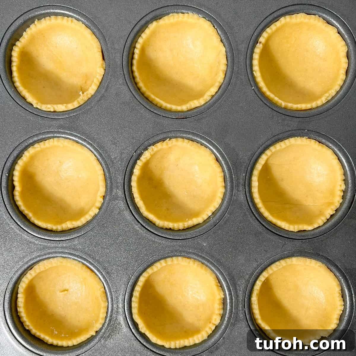 Hertzoggies: South African Jam and Coconut Tartlets Recipe 9 Pastry cases in a muffin tray.