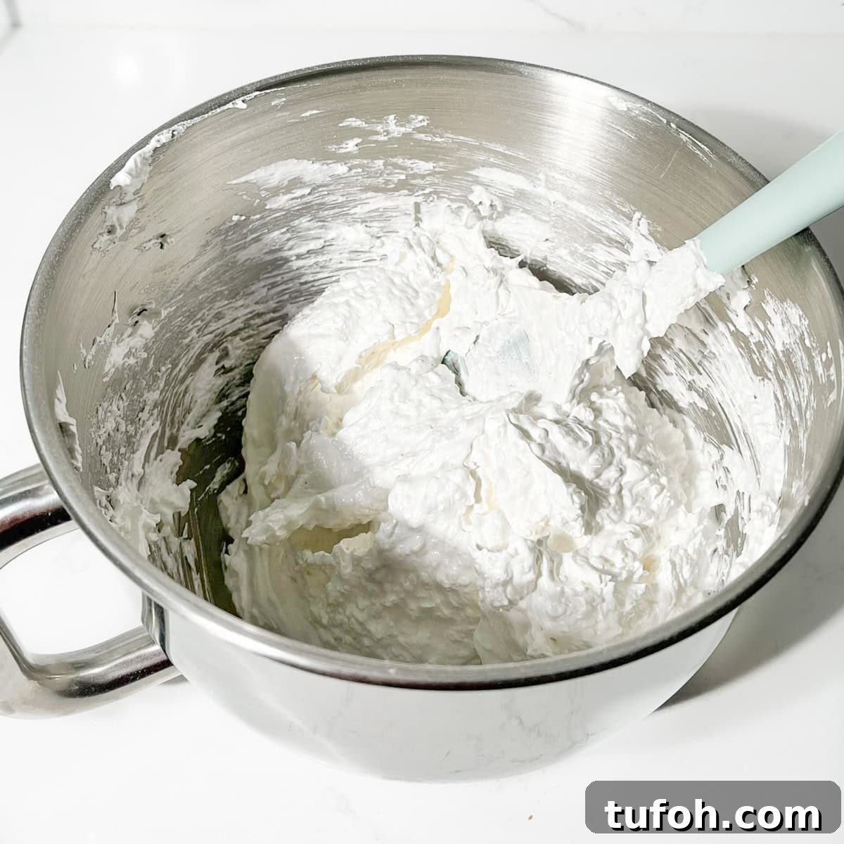 Hertzoggies: South African Jam and Coconut Tartlets Recipe 15 Meringue coconut topping in the bowl of a stand mixer.