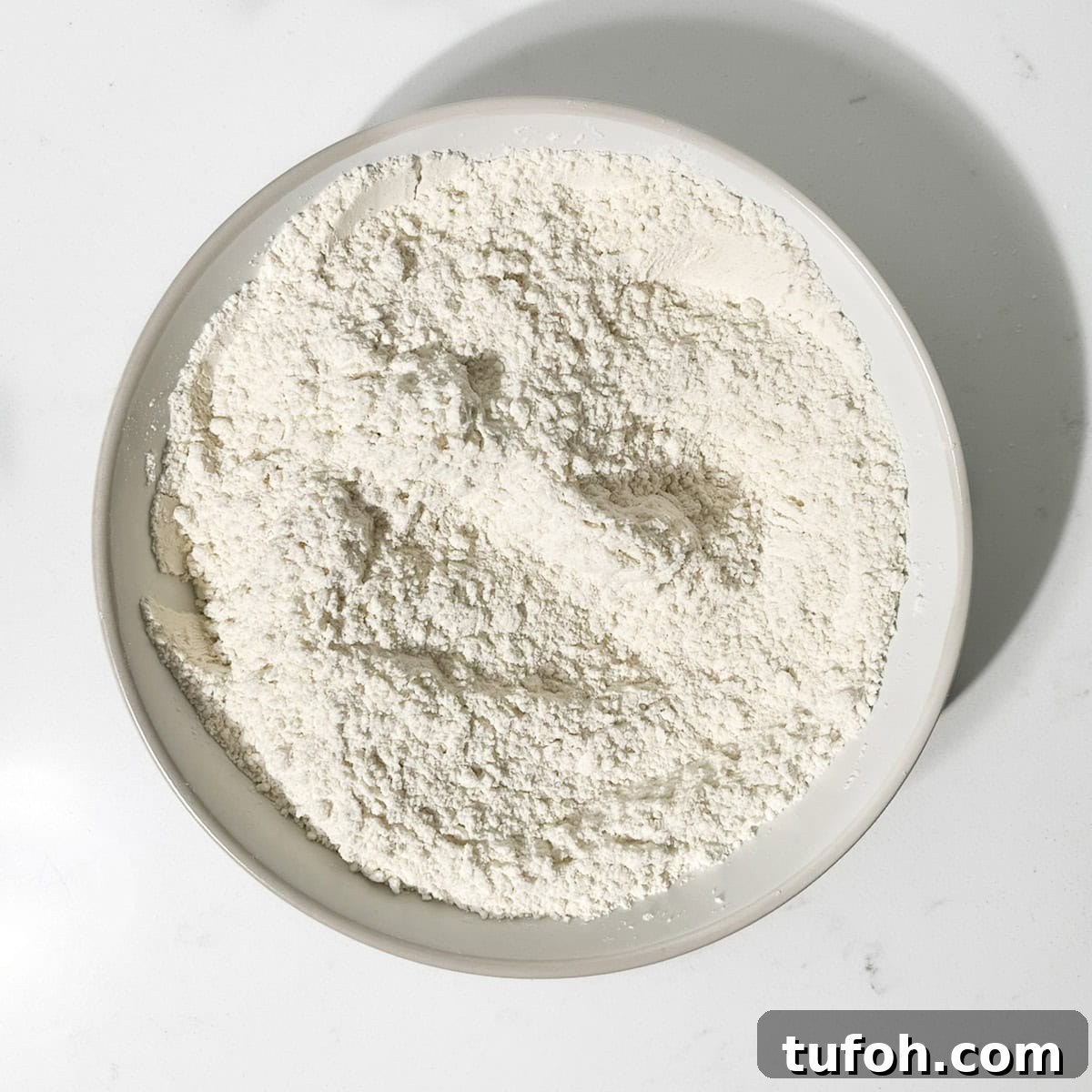 Hertzoggies: South African Jam and Coconut Tartlets Recipe 4 Dry ingredients in a white bowl for the hertzoggies.