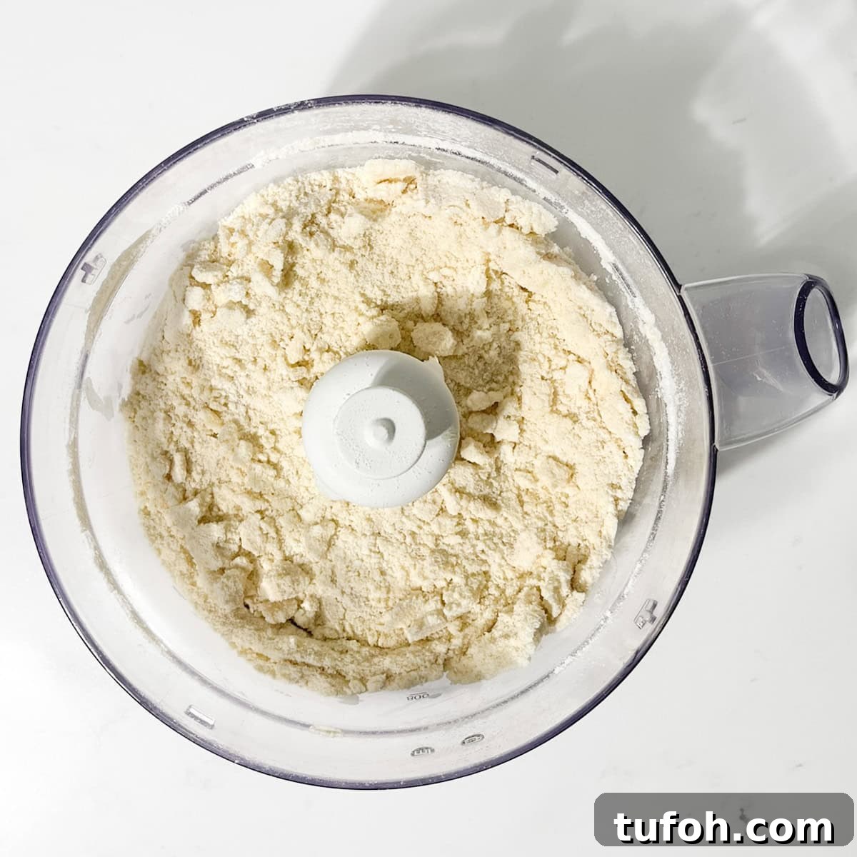 Hertzoggies: South African Jam and Coconut Tartlets Recipe 6 Pastry dough for hertzoggies in the bowl of a food processer.