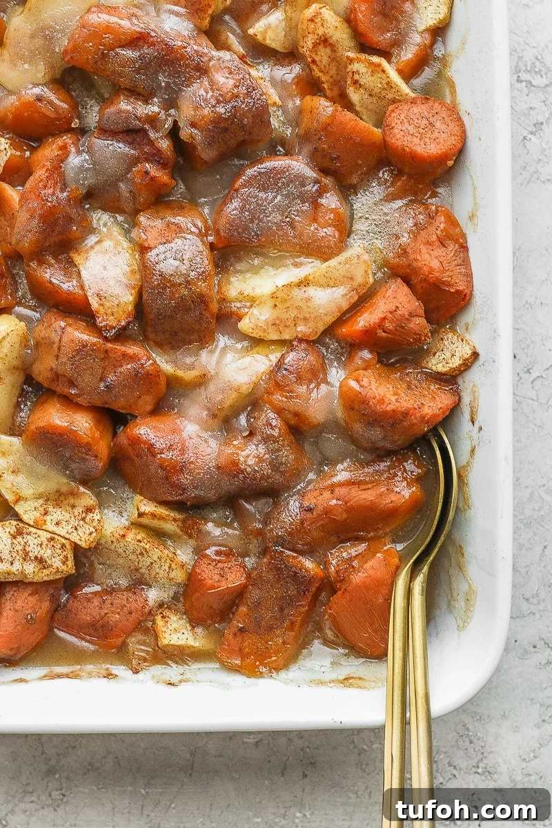 Casserole dish filled with apple yam bake and two spoons.