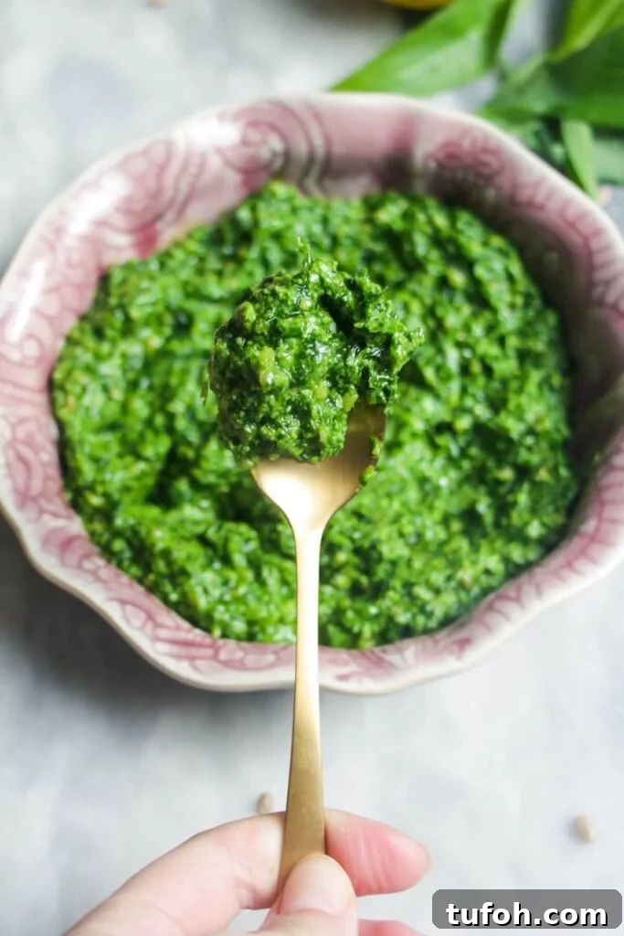 Close up of wild garlic pesto on a small gold spoon.