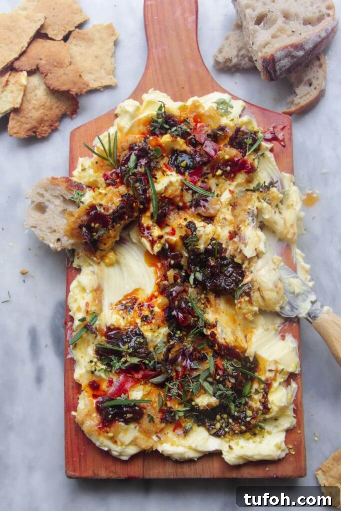 Butter smoothed onto a board and topped with chilli oil, fig chutney and herbs with bread on the side.