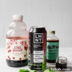 Relaxing Sleepy Girl Mocktail Recipe — Caffeine-Free Nightcap 8 A bottle of tart cherry juice, a can of LMNT electrolyte drink, elderberry syrup, mint leaves, and lime slices on a white surface.