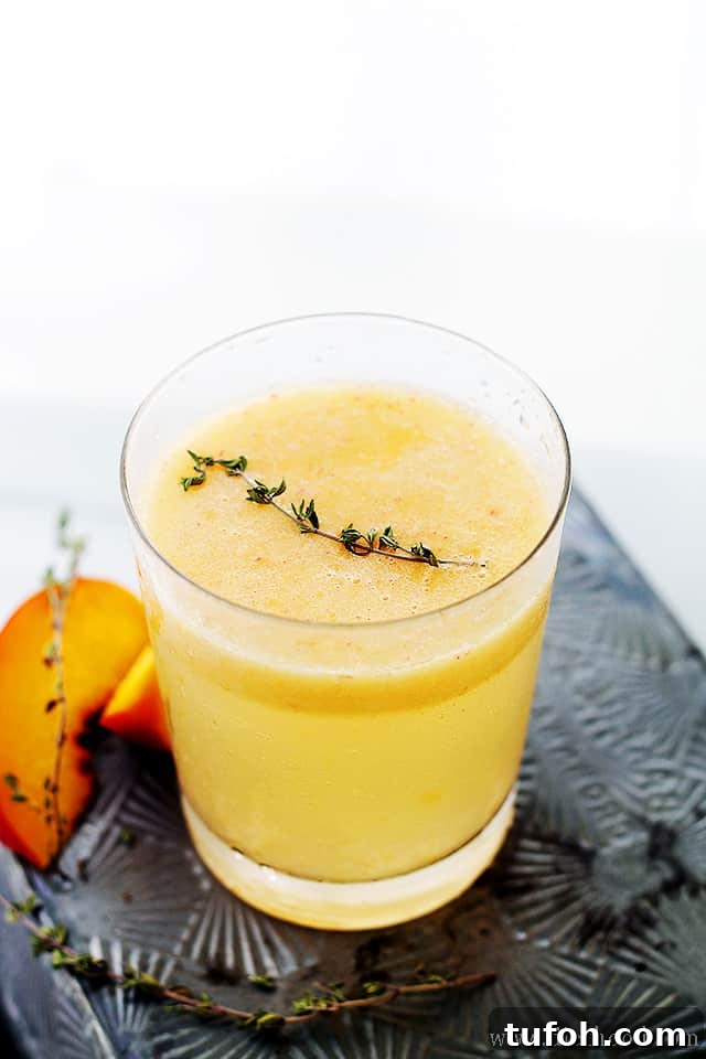 Peach Mimosas a Peach Mimosa in a glass topped with fresh thyme