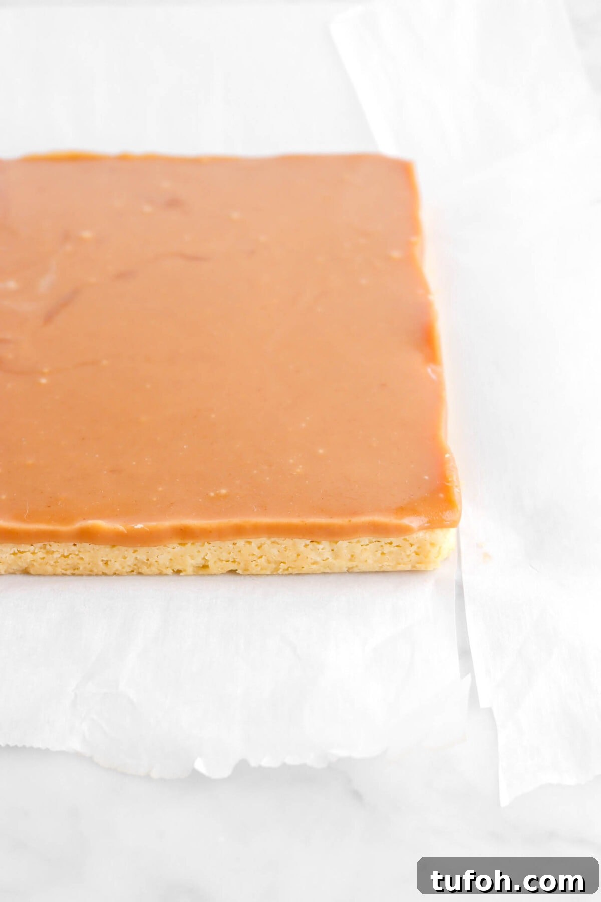 set caramel over baked shortbread on parchment paper