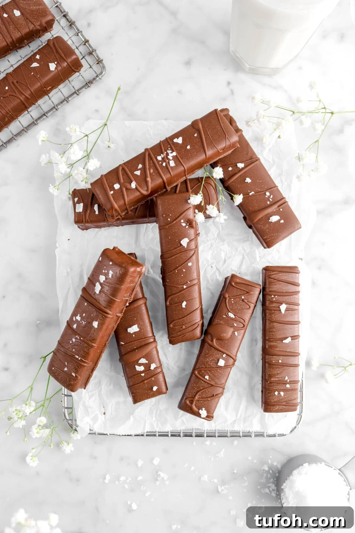 overhead shot of eight candy bars with flowers and glass of milk