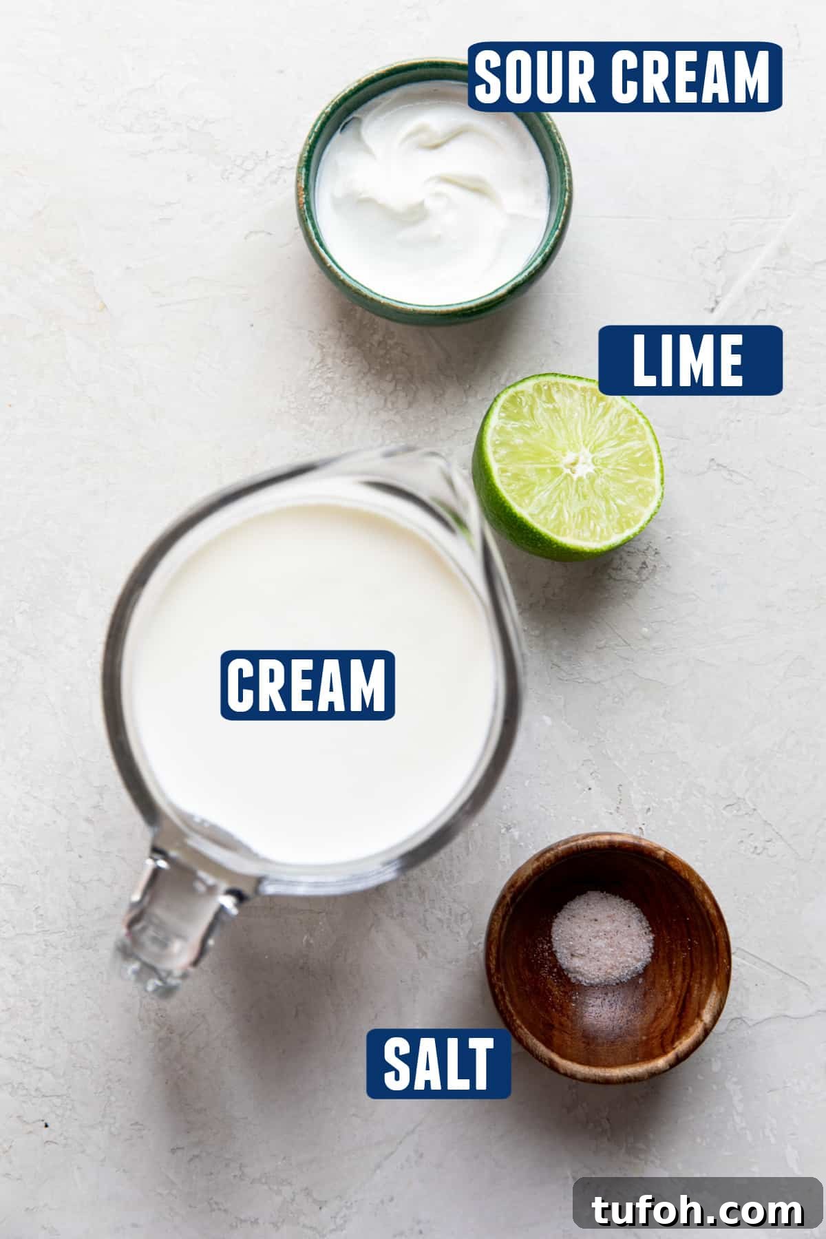 How to Make Mexican Crema at Home — Smooth, Tangy Recipe 3 Ingredients needed to make homemade mexican crema laid out on the counter. A measuring glass of cream, bowl of sour cream, half a lime, and a small amount of salt.