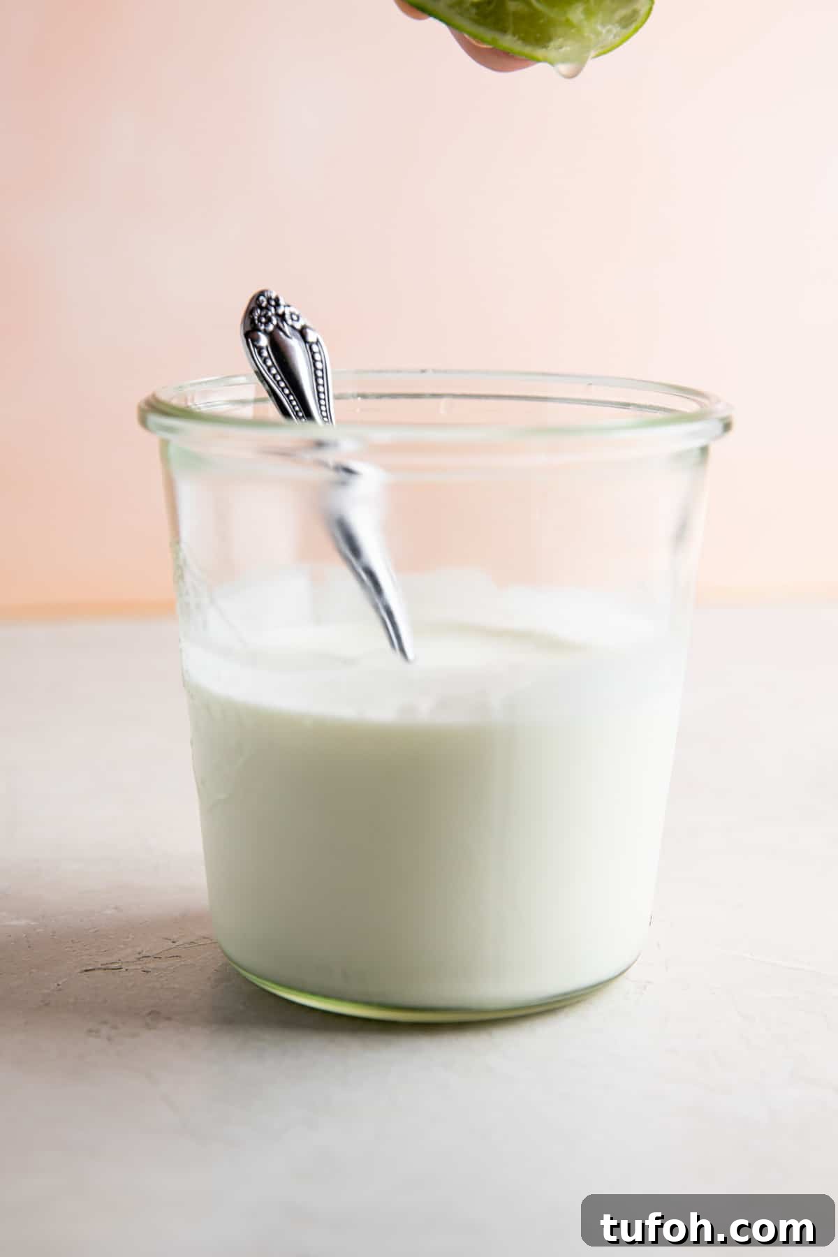 How to Make Mexican Crema at Home — Smooth, Tangy Recipe 4 Squeezing lime juice into a jar filled with Mexican sour cream.