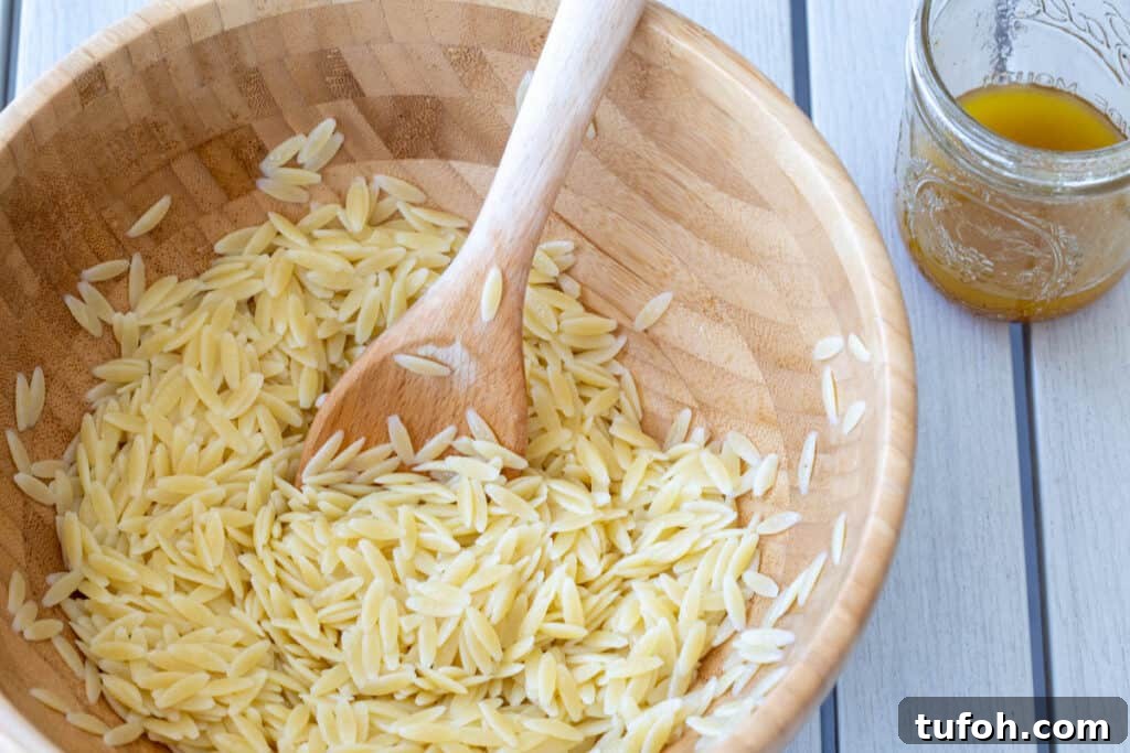 Summer Orzo (Risoni) Salad with Lemon & Fresh Herbs 7 wooden bowl with orzo pasta and mason jar of vinaigrette