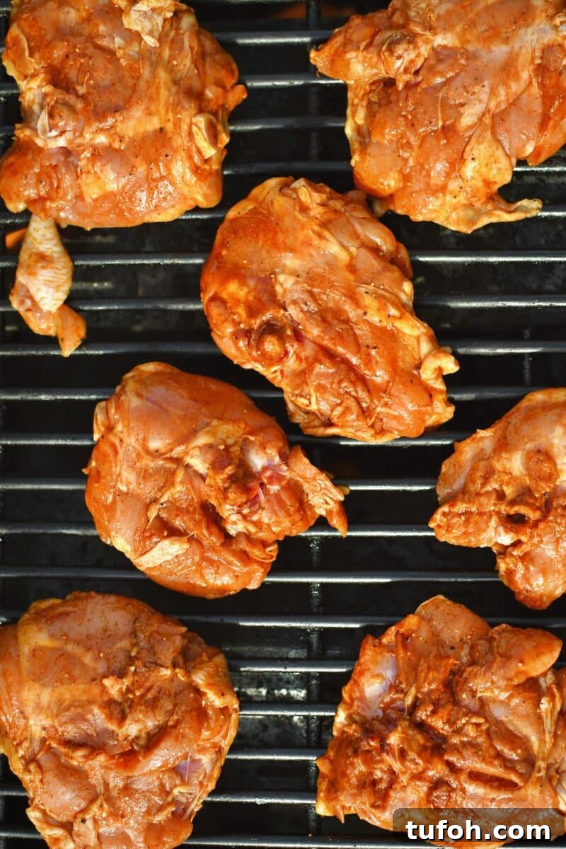 Juicy Grilled Chicken Thighs with Crispy Skin and Smoky Flavor 6 Seasoned chicken placed on the hot grill, skin side down to crisp the skin.
