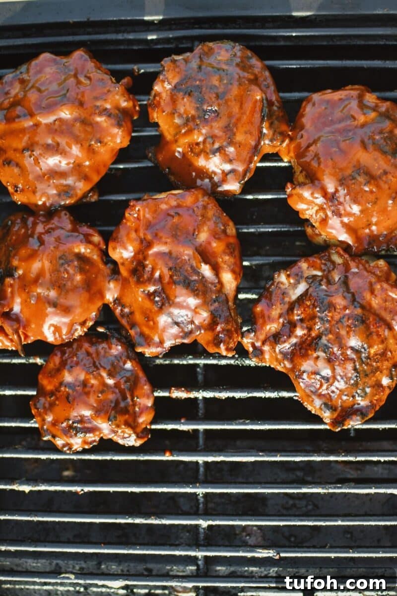 Juicy Grilled Chicken Thighs with Crispy Skin and Smoky Flavor 8 Chicken moved back over the heat and finished with bbq sauce. Close the lid to set the sauce for 5 minutes.