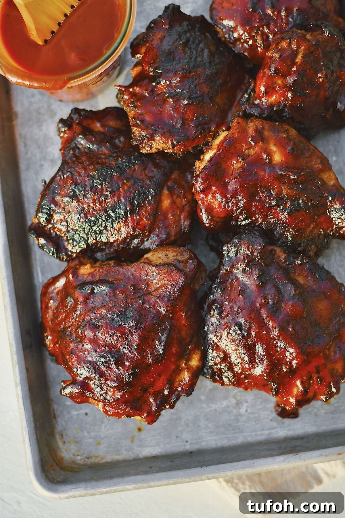 Juicy Grilled Chicken Thighs with Crispy Skin and Smoky Flavor 9 Grilled Chicken Thighs fresh off the grill and slathered in bbq sauce.