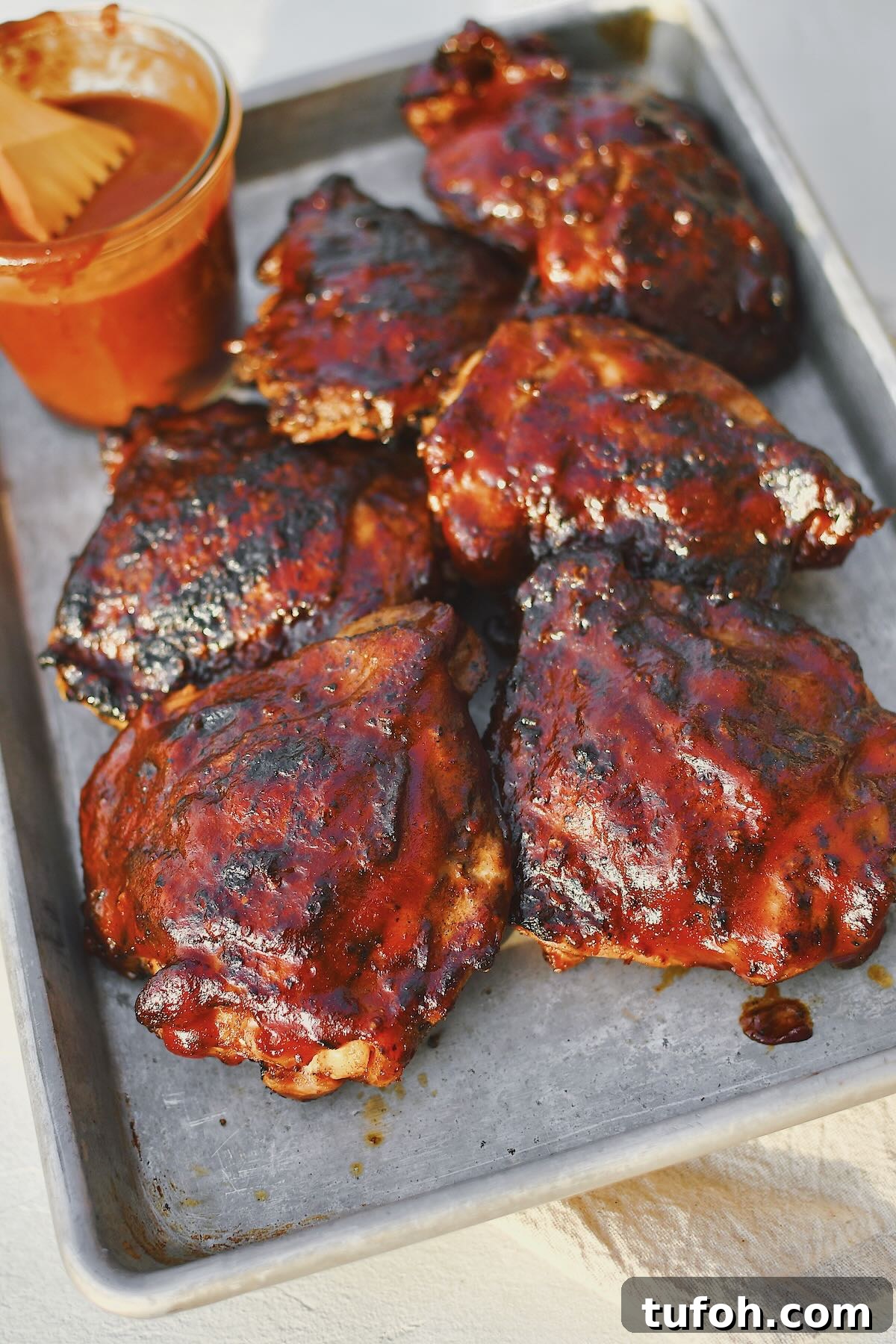 Juicy Grilled Chicken Thighs with Crispy Skin and Smoky Flavor 10 Grilled Chicken Thighs fresh off the grill and slathered in bbq sauce.