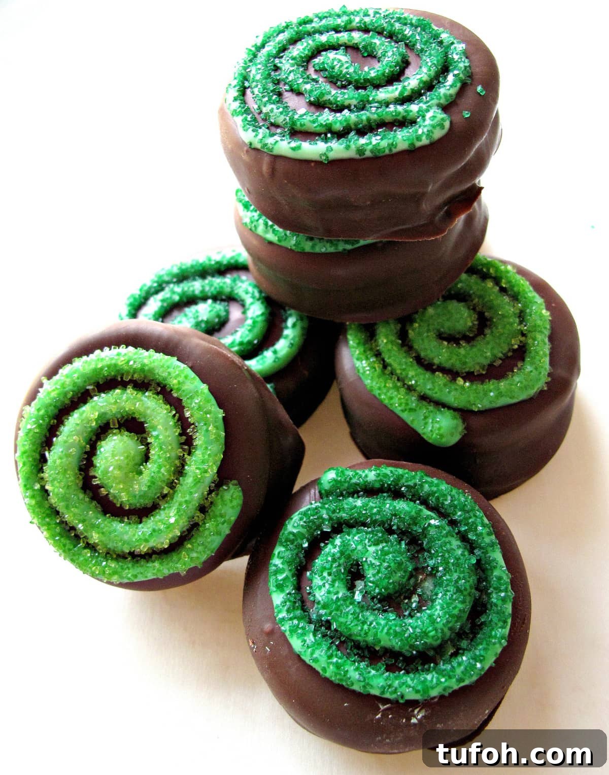 St. Patrick’s Day Chocolate-Covered Oreo Treats 2 Chocolate Covered Oreos with a green sparkle sugar coated swirl on top.