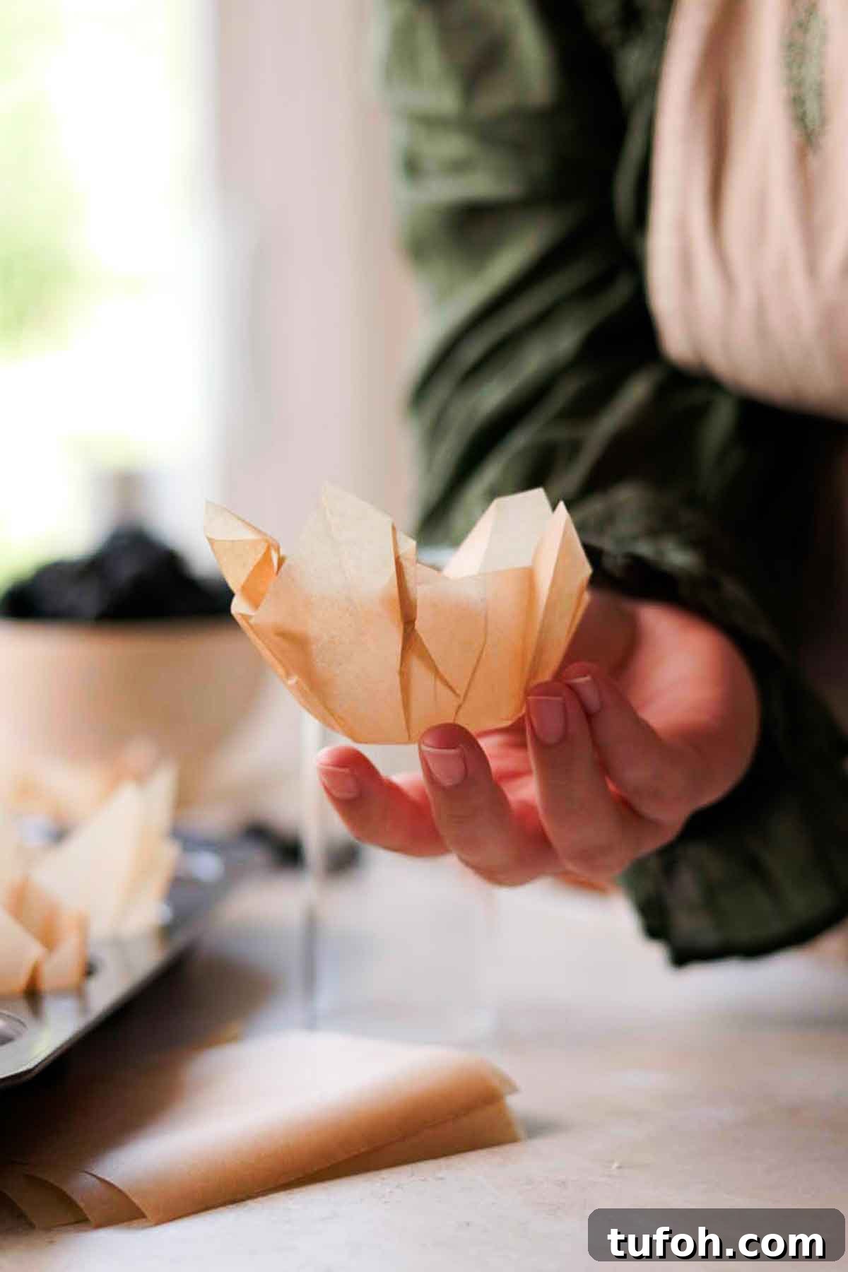 Irresistible Blackberry Muffin Recipe for Perfect Homemade Muffins 14 holding diy parchment paper liner in hand