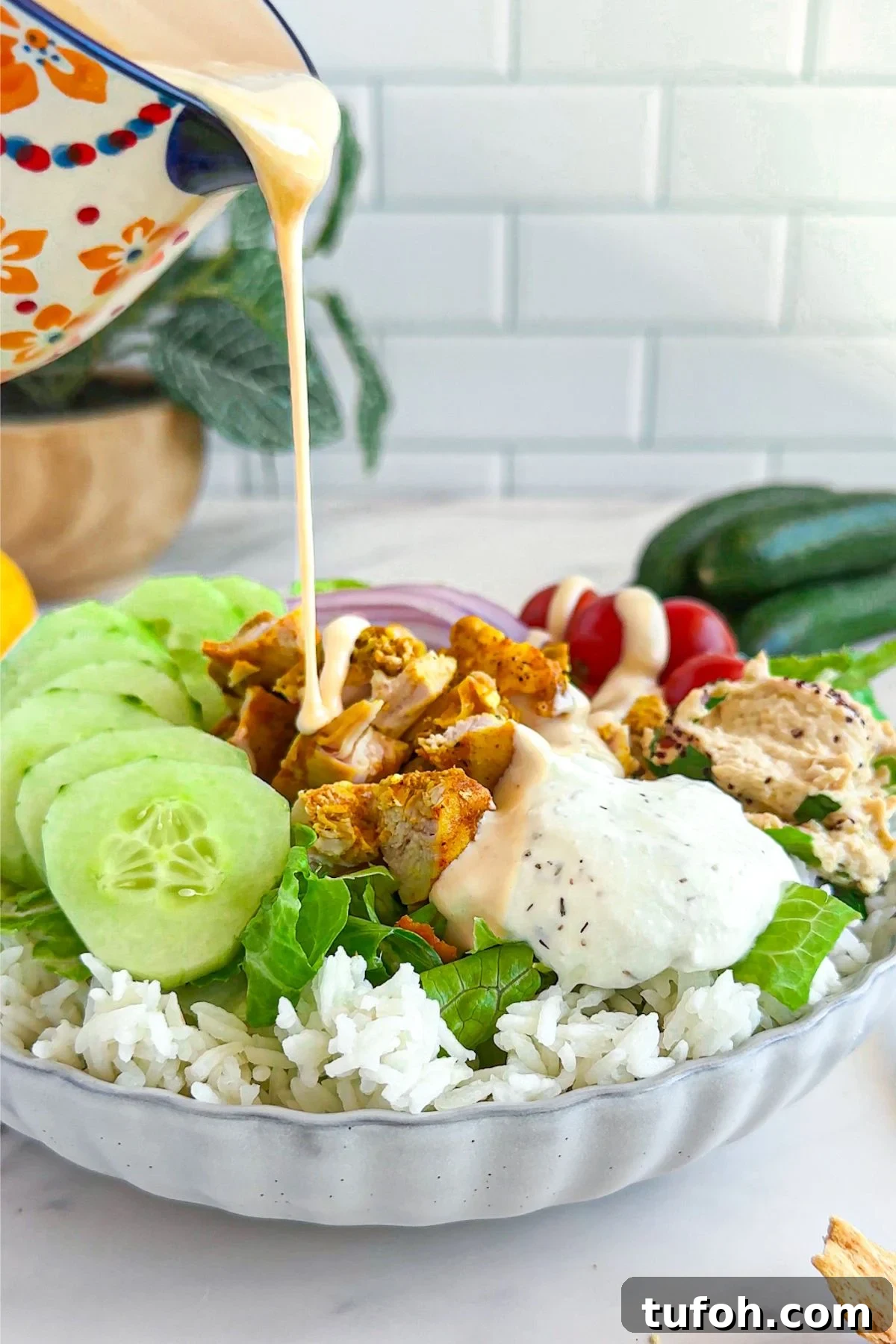 Creamy Tahini Dressing Recipe for Salads and Bowls 2 Pouring tahini dressing on a salad.