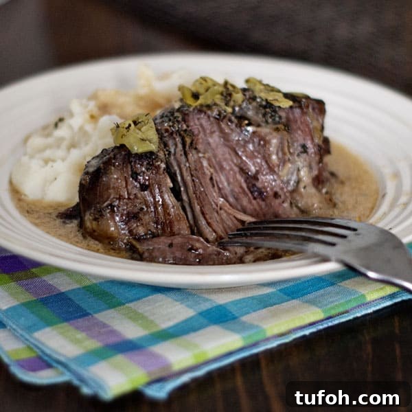 Ranchers pot roast seasoned with ranch dressing and pepperoncini, finished with a sour cream gravy. Ranchers on plate with gravy and mashed potatoes