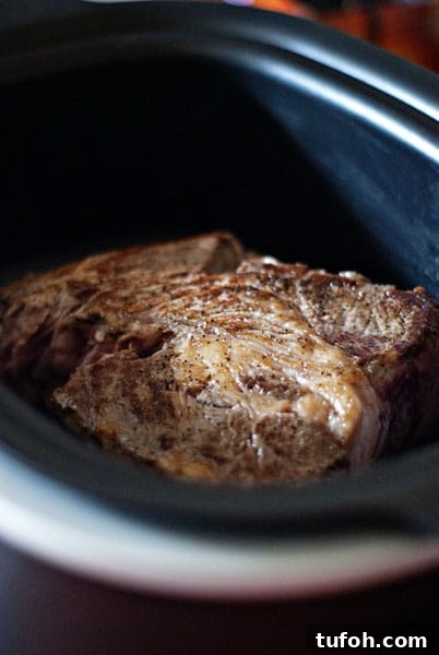 Searing the chuck roast before placing in the crock pot. roast beef in crock pot