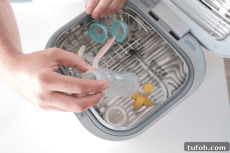 Sanitize and Sterilize Your Belongings Safely and Effectively 4 A top open view of the sanitizer with a woman's hand putting baby bottles into it.