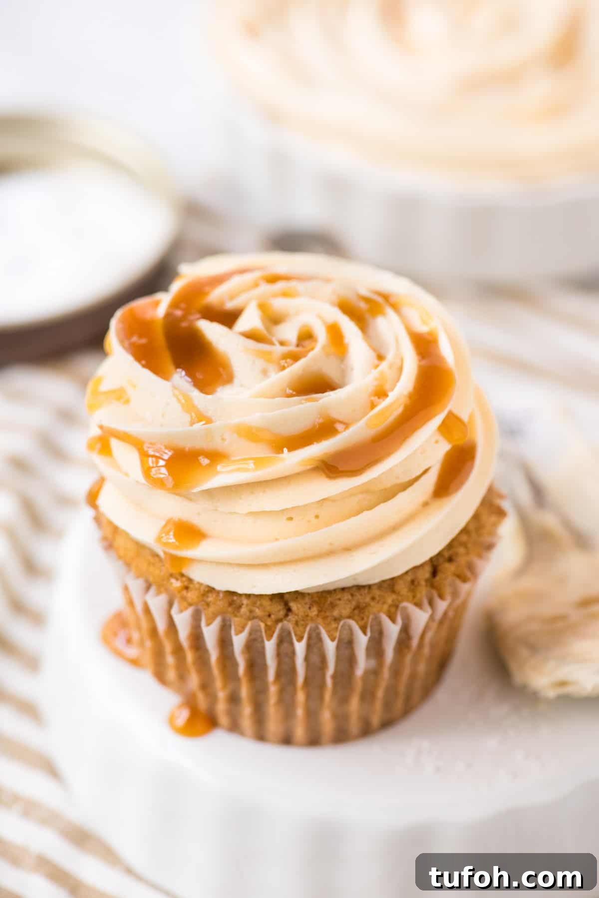 Silky Salted Caramel Frosting Recipe for Cakes & Cupcakes 3 salted caramel frosting piped on cupcake on white background