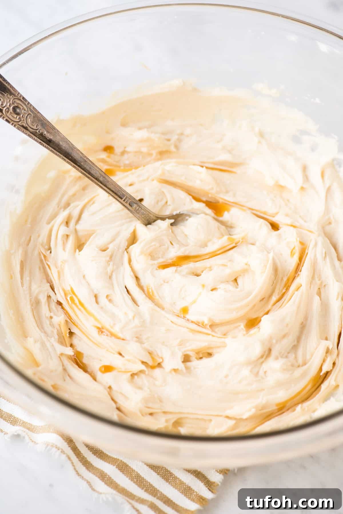Silky Salted Caramel Frosting Recipe for Cakes & Cupcakes 6 salted caramel frosting with caramel sauce swirled in glass bowl