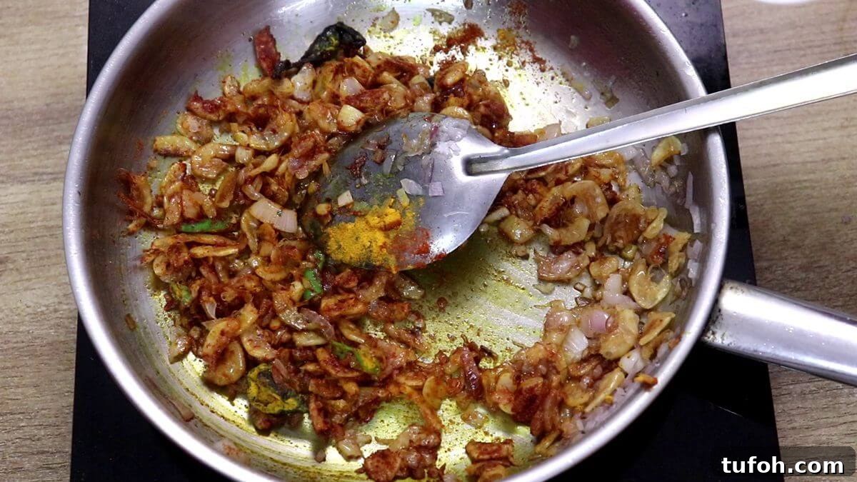 addition of spice powders and combining them for prawns kismoor recipe.