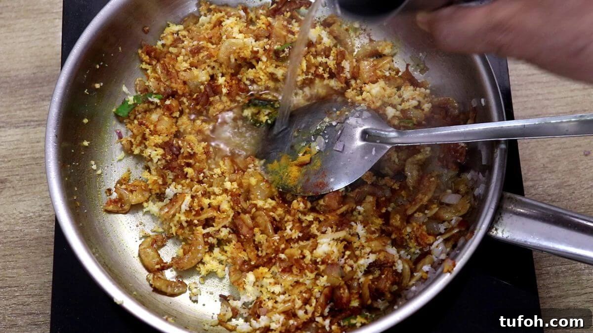 adding a splash of water to prawns kismoor.