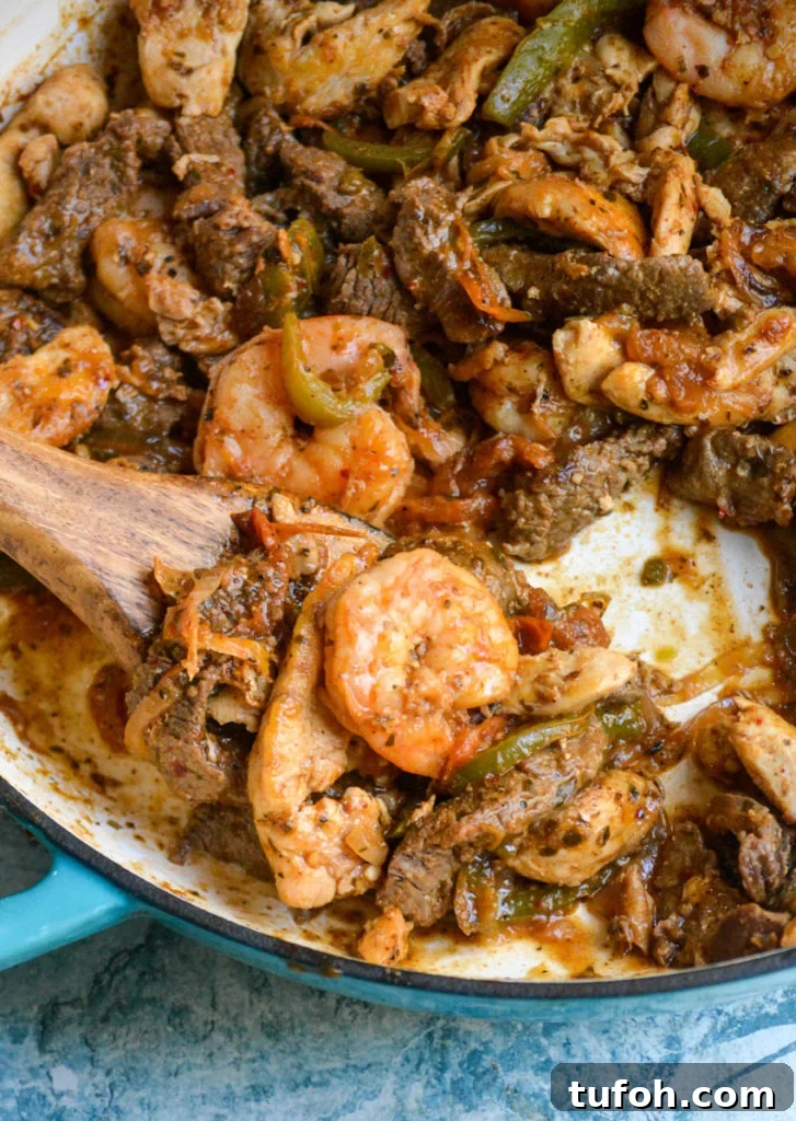 Texas fajitas filling shown in an enameled cast iron skillet with a wooden spatula