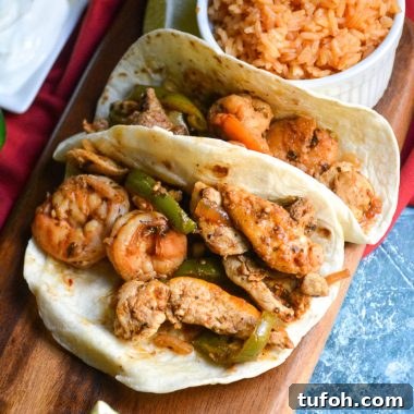 Texas fajitas arranged on a narrow wooden cutting board with a small bowl of spanish rice