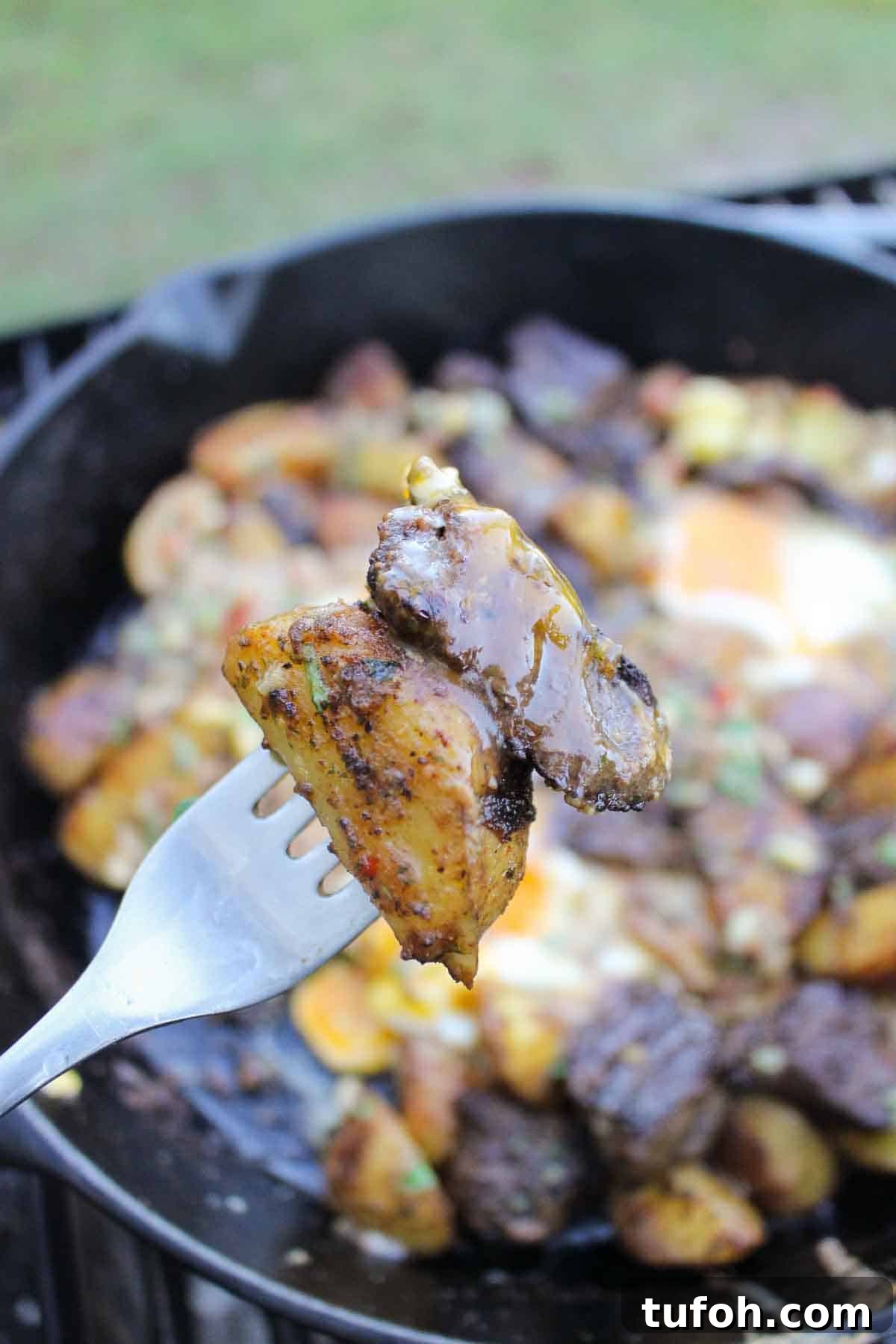 A forkful of potatoes and steak.
