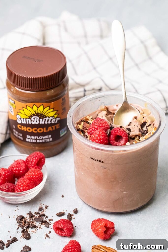 A pint of chocolate protein ice cream next to a jar of chocolate sunbutter.