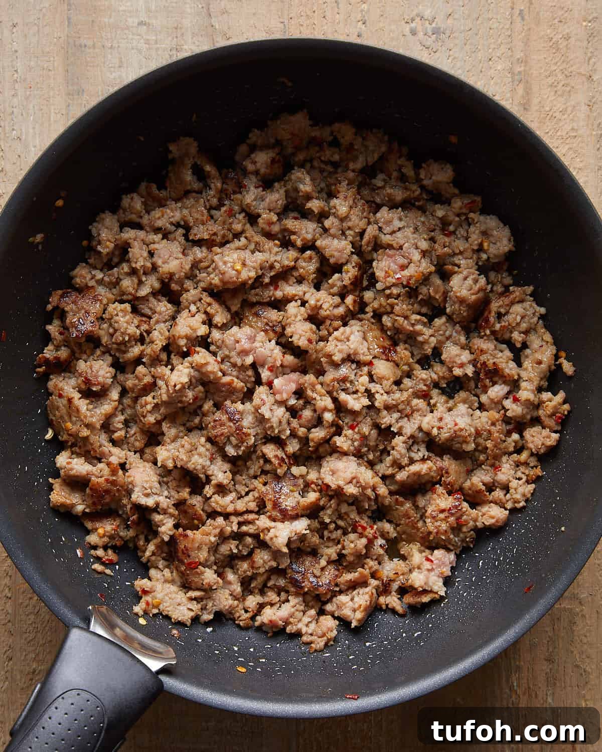 Cooked Italian sausage crumbled and browned in a skillet for baked stuffed shells.