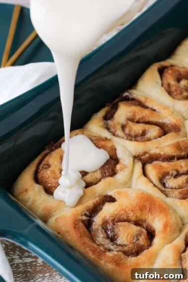 Flaky Apple Cinnamon Rolls with Brown Sugar Glaze 7 The best cinnamon rolls glaze pouring over baked rolls.